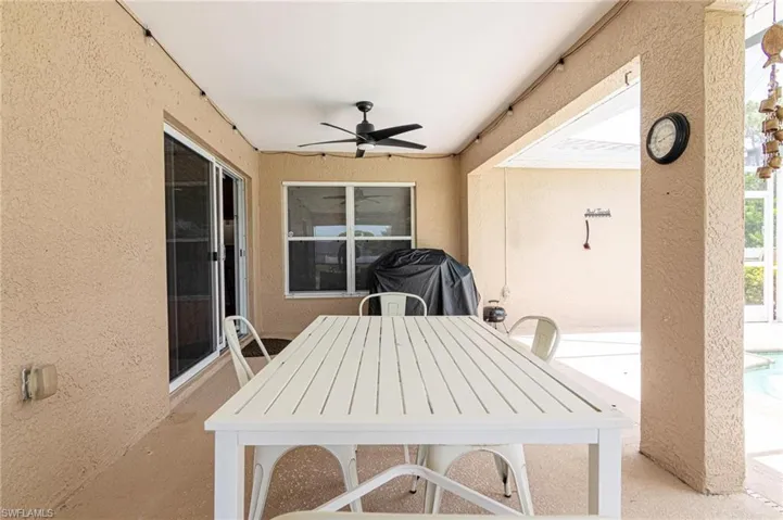 View of patio / terrace featuring a ceiling fan, outdoor dining area, a pool, and a grill