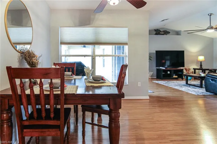 Dining room with ceiling fan, wood finished floors, lofted ceiling, and baseboards