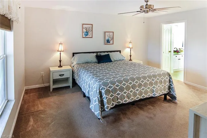 Bedroom with carpet, baseboards, and connected bathroom