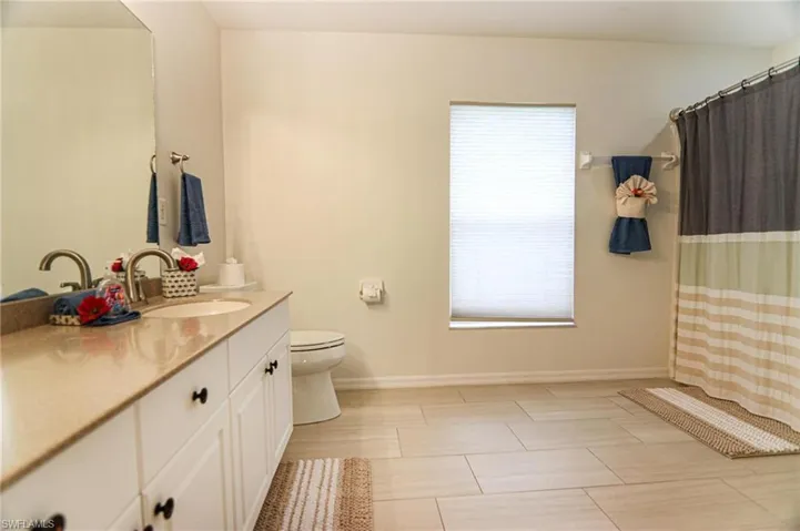Full bath featuring vanity, plenty of natural light, toilet, and baseboards