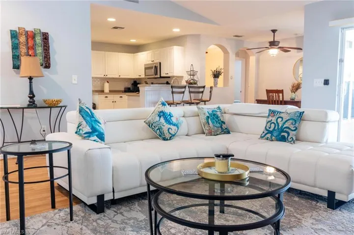 Living area featuring ceiling fan, arched walkways, recessed lighting, and light wood-type flooring