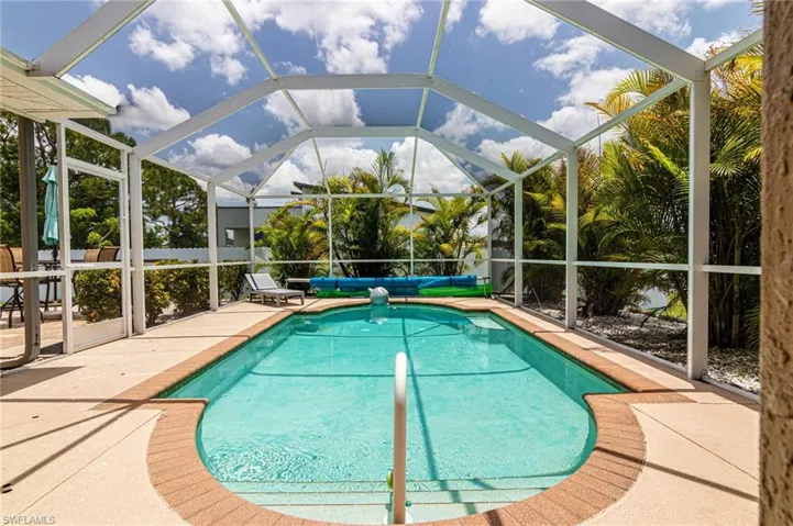 Swimming pool featuring a patio area and glass enclosure