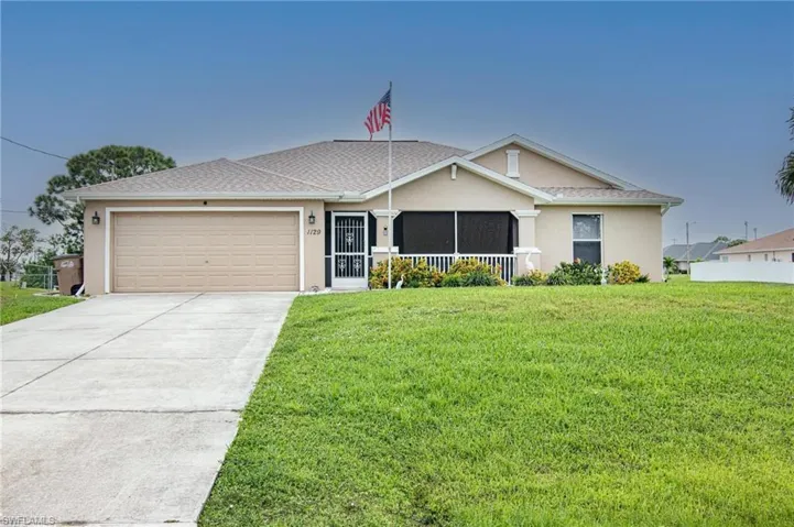 Ranch-style house with stucco siding, an attached garage, and a front yard