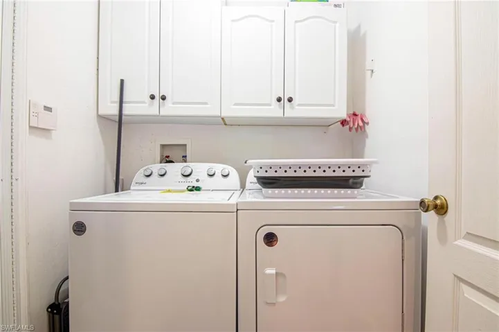 Laundry room featuring cabinet space and washer and clothes dryer