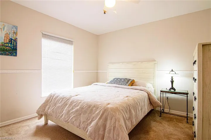 Bedroom with carpet floors, baseboards, and a ceiling fan
