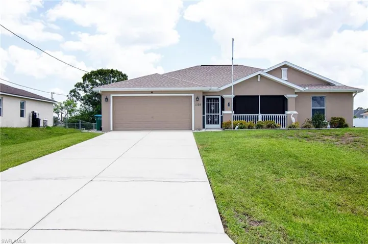 Single story home featuring stucco siding, a garage, a front yard, and driveway