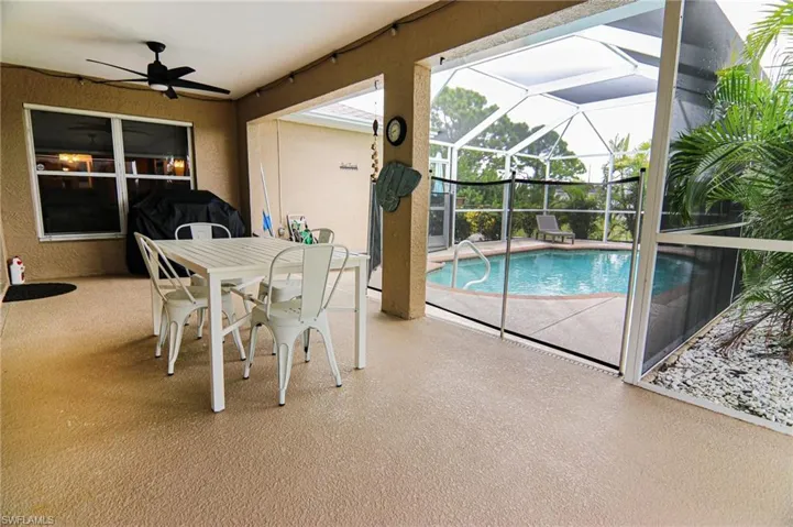 Outdoor pool with a patio area, ceiling fan, a lanai, and outdoor dining area