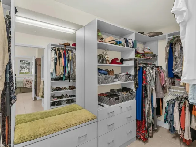 Walk in closet with light tile patterned floors