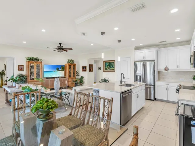 Kitchen featuring stainless steel appliances, a kitchen island with sink, sink, pendant lighting, and white cabinets