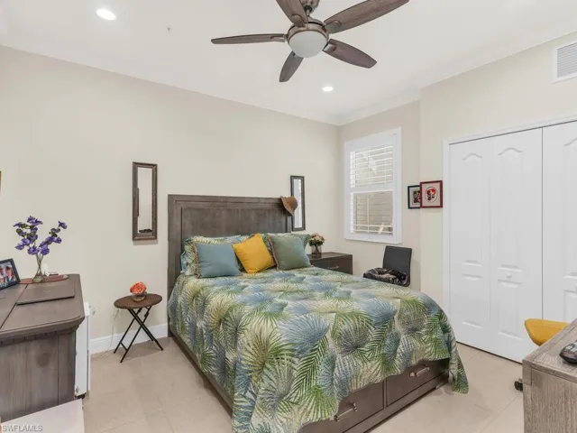 Tiled bedroom featuring a closet, ceiling fan, and crown molding