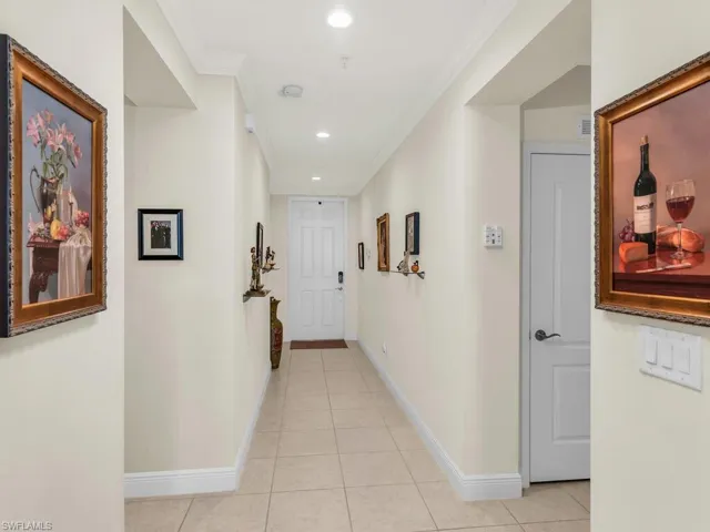 Corridor with light tile patterned floors and ornamental molding