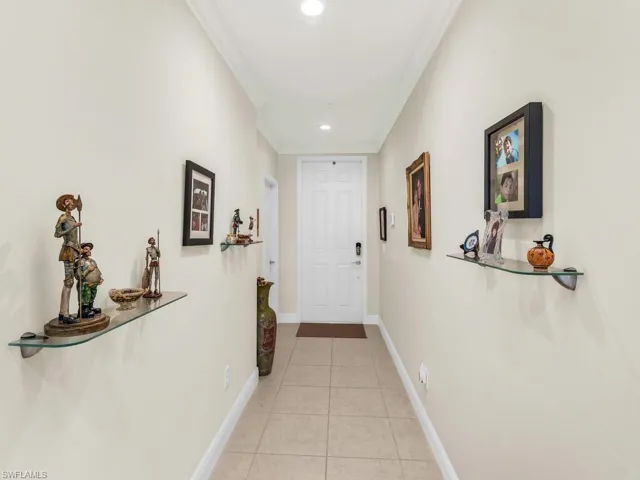 Corridor with light tile patterned floors and ornamental molding