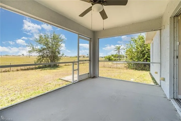 Unfurnished sunroom with a ceiling fan and a view of rural / pastoral area