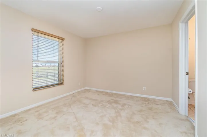 bedroom with light colored carpet and baseboards