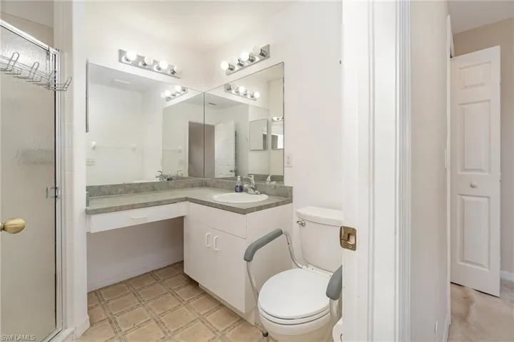 Bathroom featuring toilet, a stall shower, and vanity