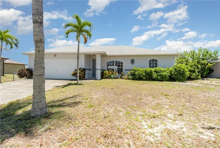 Single story home with concrete driveway, a garage, stucco siding, and a front yard