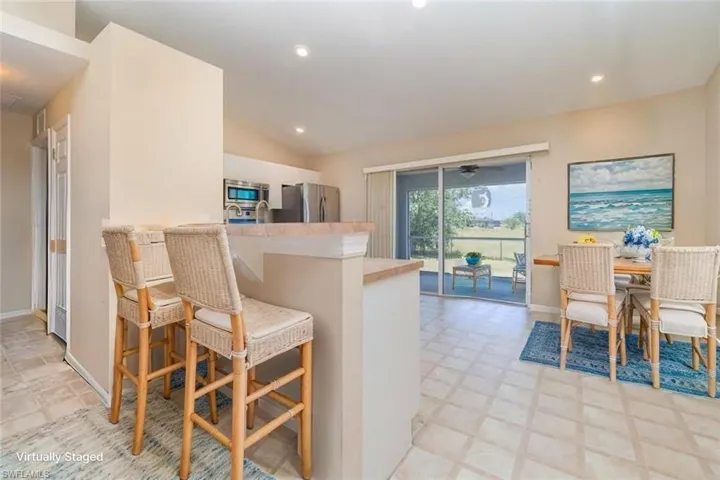 Kitchen featuring appliances with stainless steel finishes, vaulted ceiling, recessed lighting, a peninsula, and light countertops