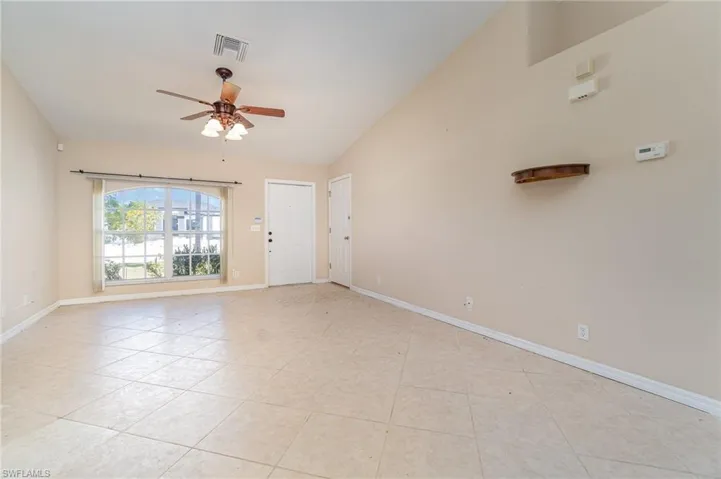 room featuring vaulted ceiling, ceiling fan, light tile patterned floors, and baseboards
