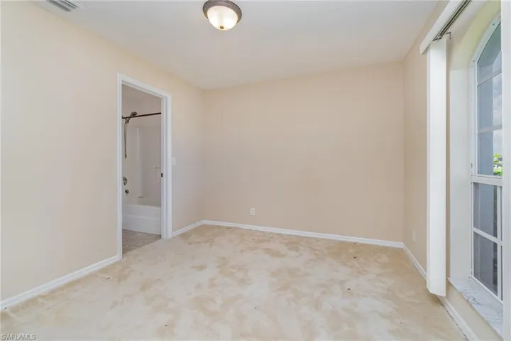 bedroom featuring carpet flooring, baseboards, and ensuite bath