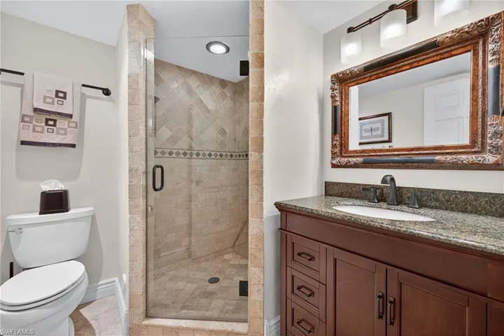 Full bathroom with vanity, a stall shower, and light tile patterned floors