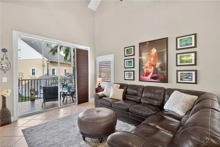 Living area featuring light tile patterned floors, a high ceiling, and a ceiling fan