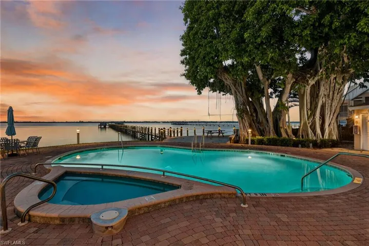 Community pool with a water view, a community hot tub, and a patio