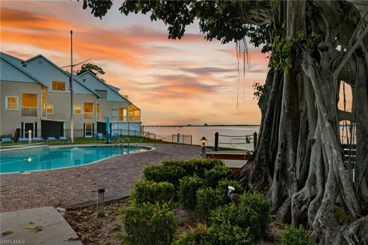 Pool at dusk with a patio and a water view