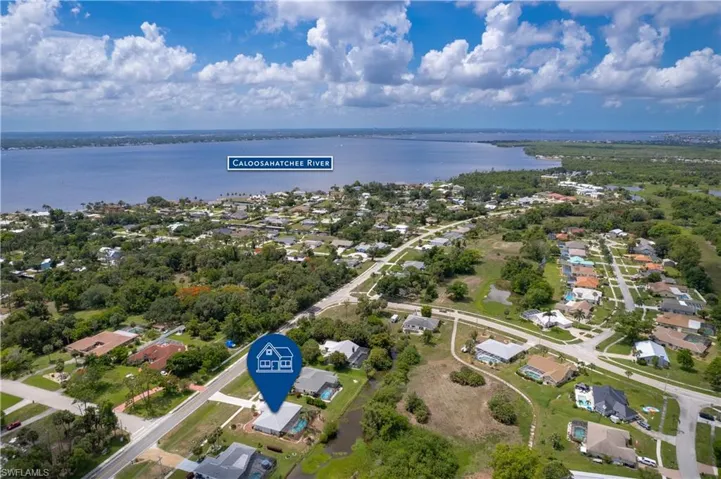 Aerial view of property's location with a large body of water and nearby suburban area