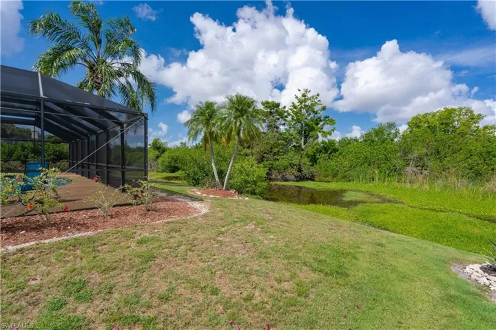 View of grassy yard with a lanai