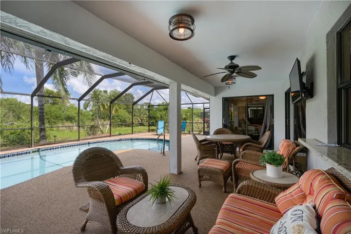 Outdoor pool featuring a patio, ceiling fan, and a lanai