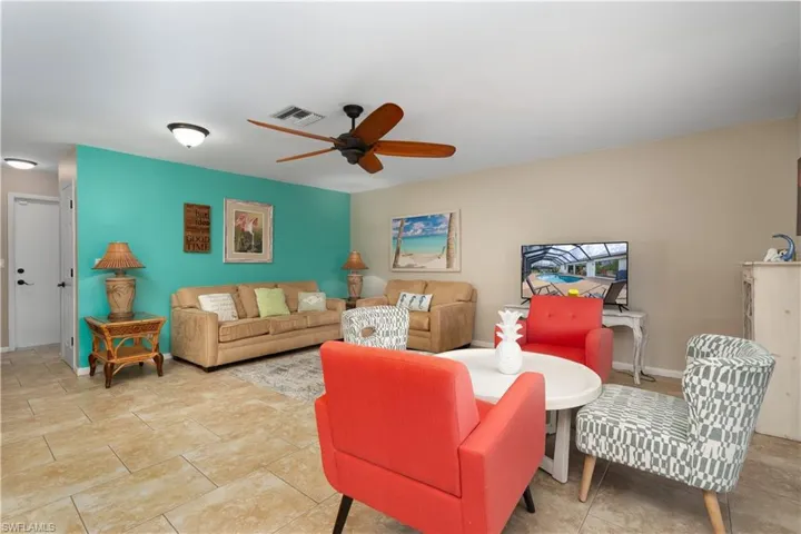 Living area with a ceiling fan and baseboards