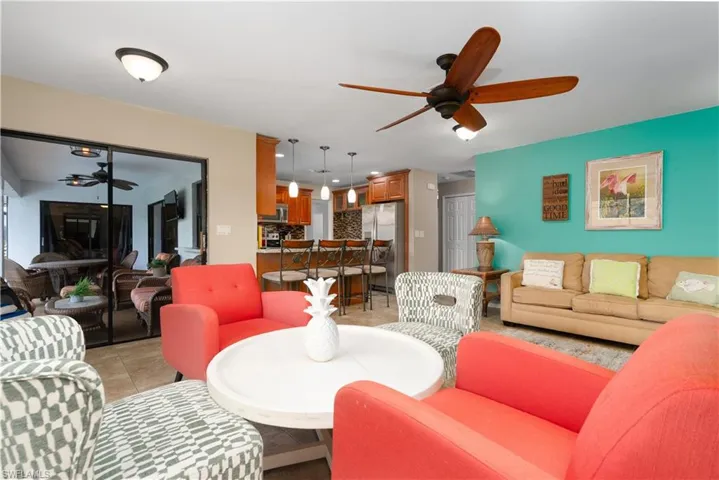 Living area with a ceiling fan and light tile patterned floors