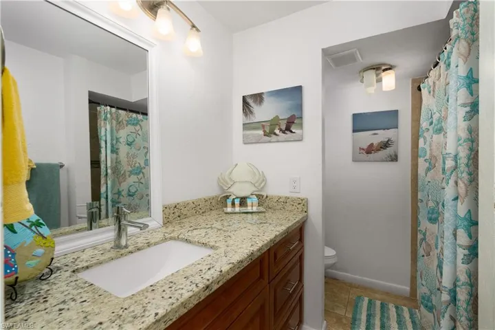 Full bath featuring vanity, toilet, and tile patterned floors