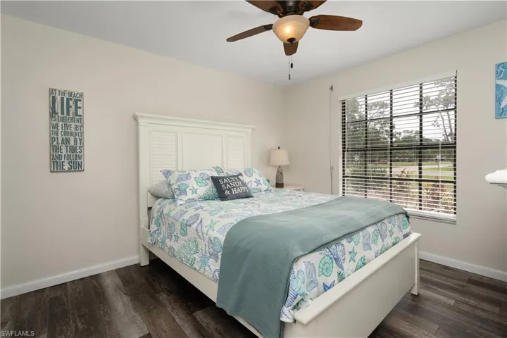 Bedroom featuring baseboards, wood finished floors, and a ceiling fan