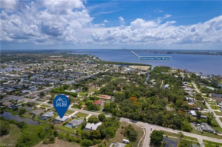 Aerial view of property's location featuring a large body of water and nearby suburban area