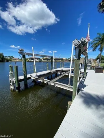 Dock area featuring boat lift and a water view