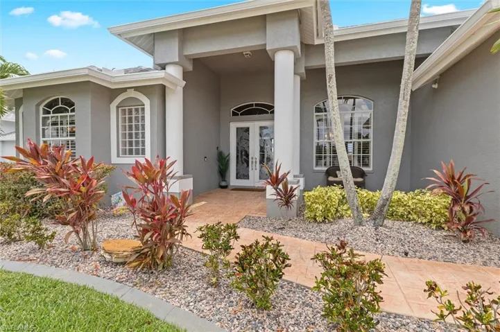 Doorway to property featuring stucco siding and french doors