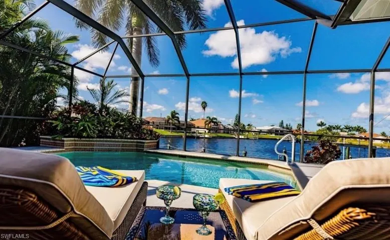 Swimming pool with glass enclosure, a sunroom, and a water view
