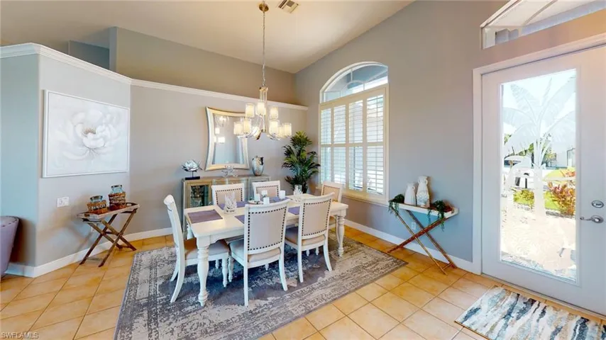 Dining room with light tile patterned floors and a chandelier