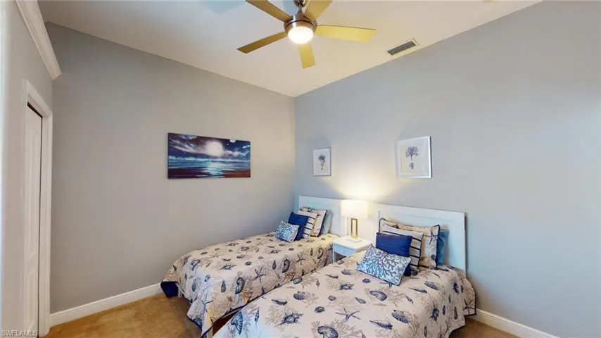 Carpeted bedroom with a ceiling fan and a closet