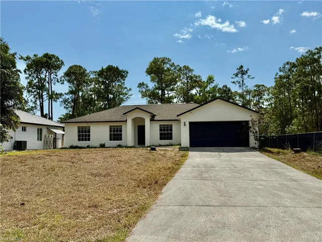 Single story home with concrete driveway, an attached garage, stucco siding, central AC, and roof with shingles