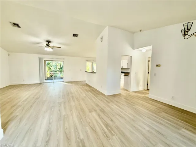 Unfurnished living room featuring ceiling fan, baseboards, and light wood-style flooring