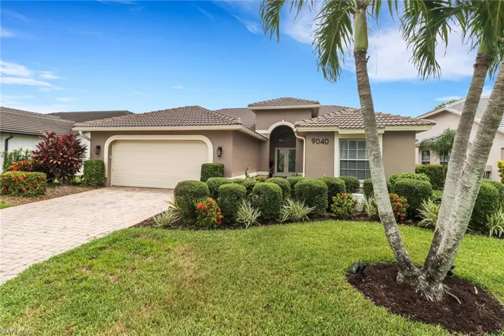 Mediterranean / spanish-style house with stucco siding, decorative driveway, a front lawn, and a tiled roof