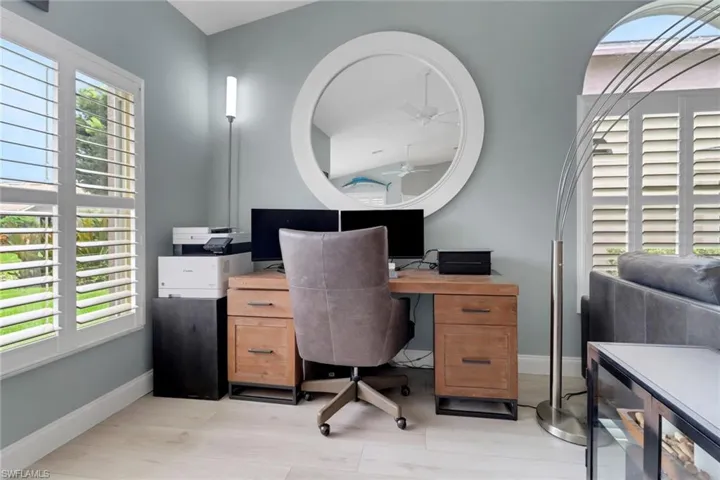 Office area featuring healthy amount of natural light, ceiling fan, and light wood finished floors