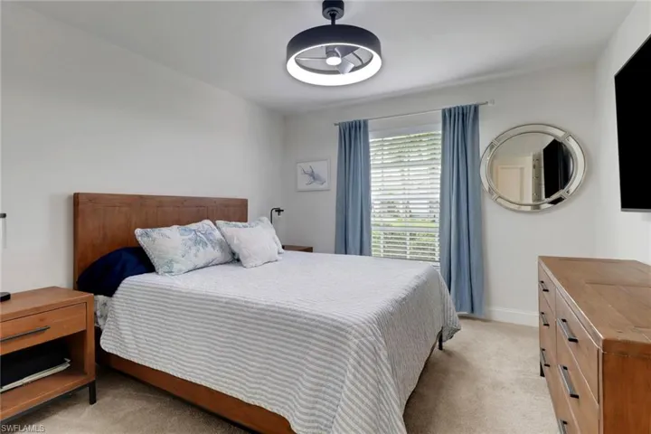 Bedroom featuring light carpet and baseboards