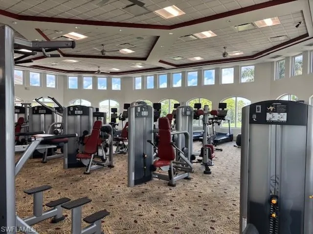 Workout area with a towering ceiling, ceiling fan, and recessed lighting