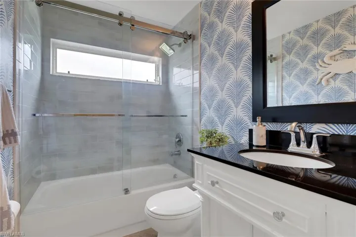 Full bath featuring vanity and combined bath / shower with glass door