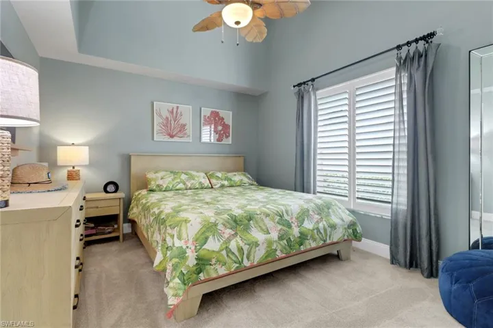 Bedroom with light carpet and a ceiling fan
