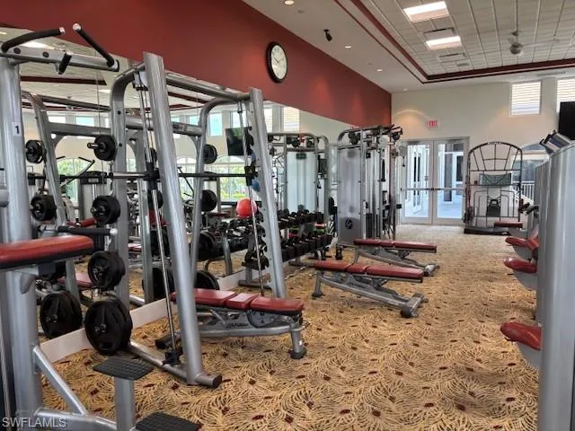 Gym featuring a towering ceiling and ceiling fan