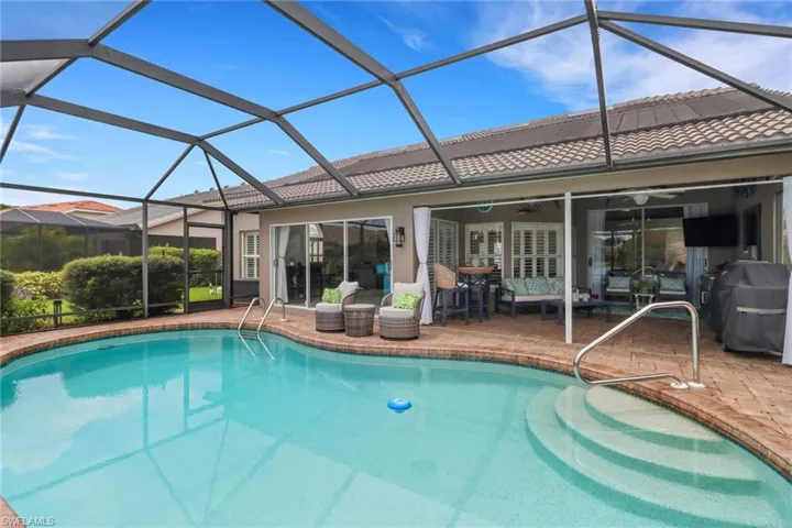 Swimming pool with a sunroom, a lanai, and a patio